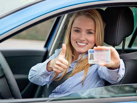 A Woman In A Car Showing Her Driver's License in Texas